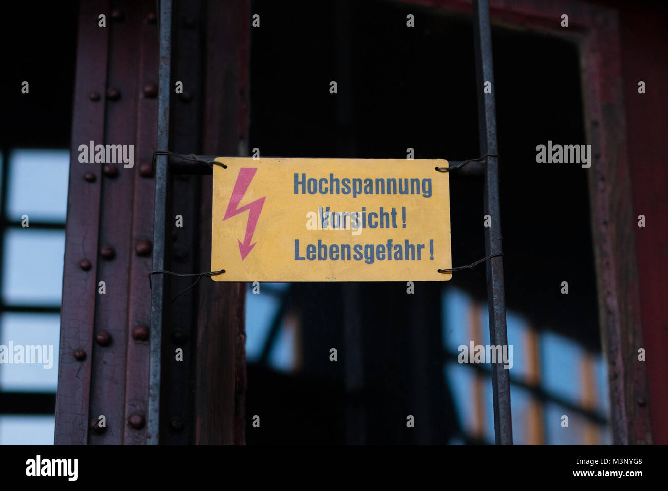 Elettricità segno di avvertimento con flash simbolo e testo tedesco: Hochspannung Vorsicht Lebensgefahr ( Alta tensione pericolo mortale) Foto Stock