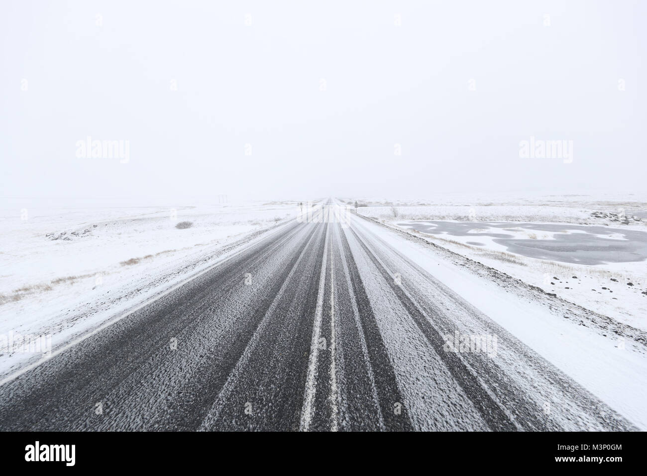 Snowy strada pericolosa in un solitario paesaggio di campagna Foto Stock