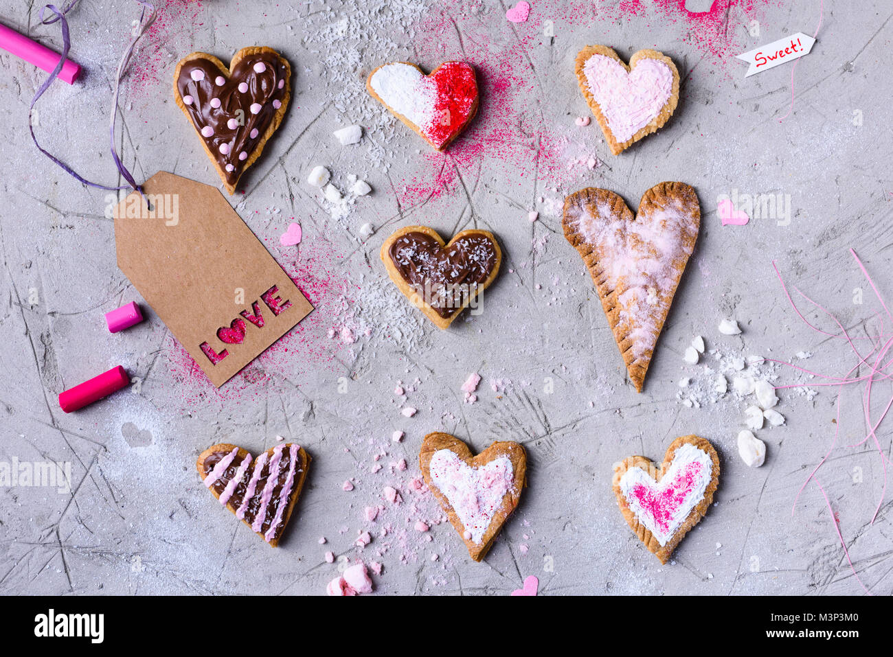 Vista superiore del dolce a forma di cuore i cookie con amore tag grigio sulla superficie incrinato Foto Stock