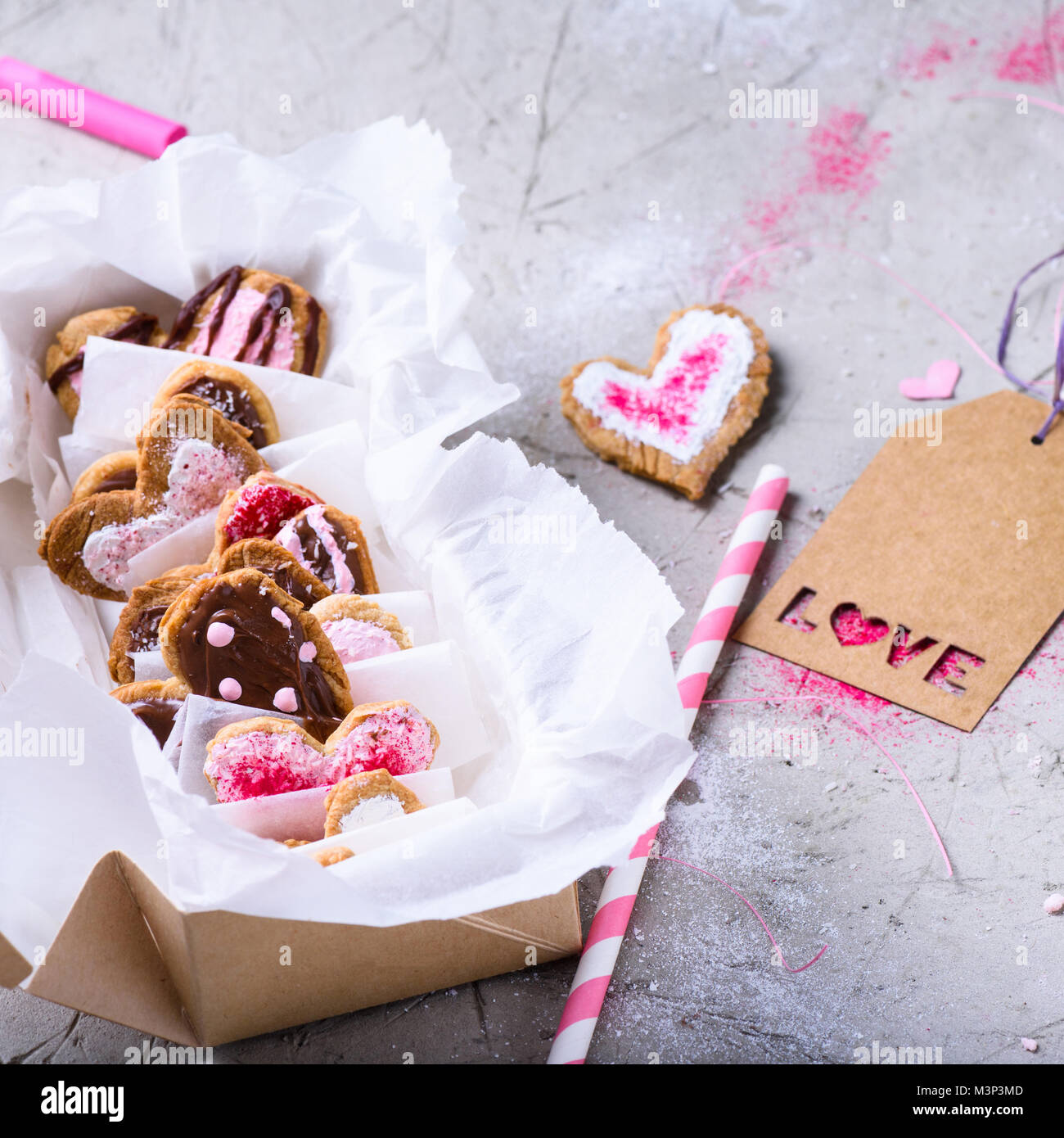 Vista ravvicinata di scatola con dolce di san valentino gourmet cookies con amore etichetta sulla superficie grigia Foto Stock