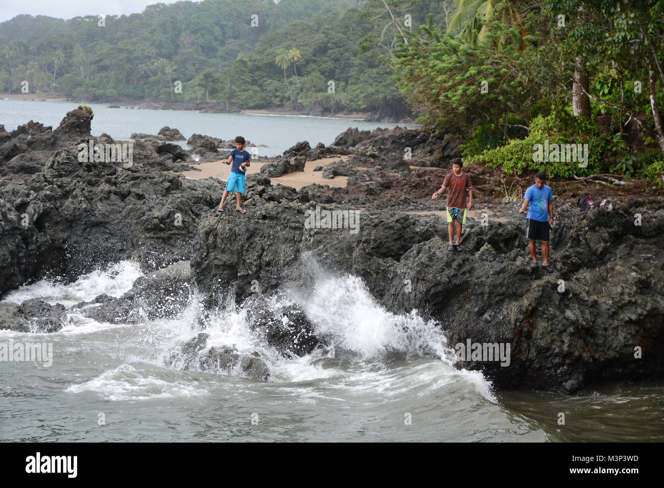 Una Costa Rican l uomo e i suoi figli si impegnano in attività di pesca tradizionale con solo una linea e un gancio sulla costa del Pacifico, vicino a Drake Bay, Costa Rica. Foto Stock