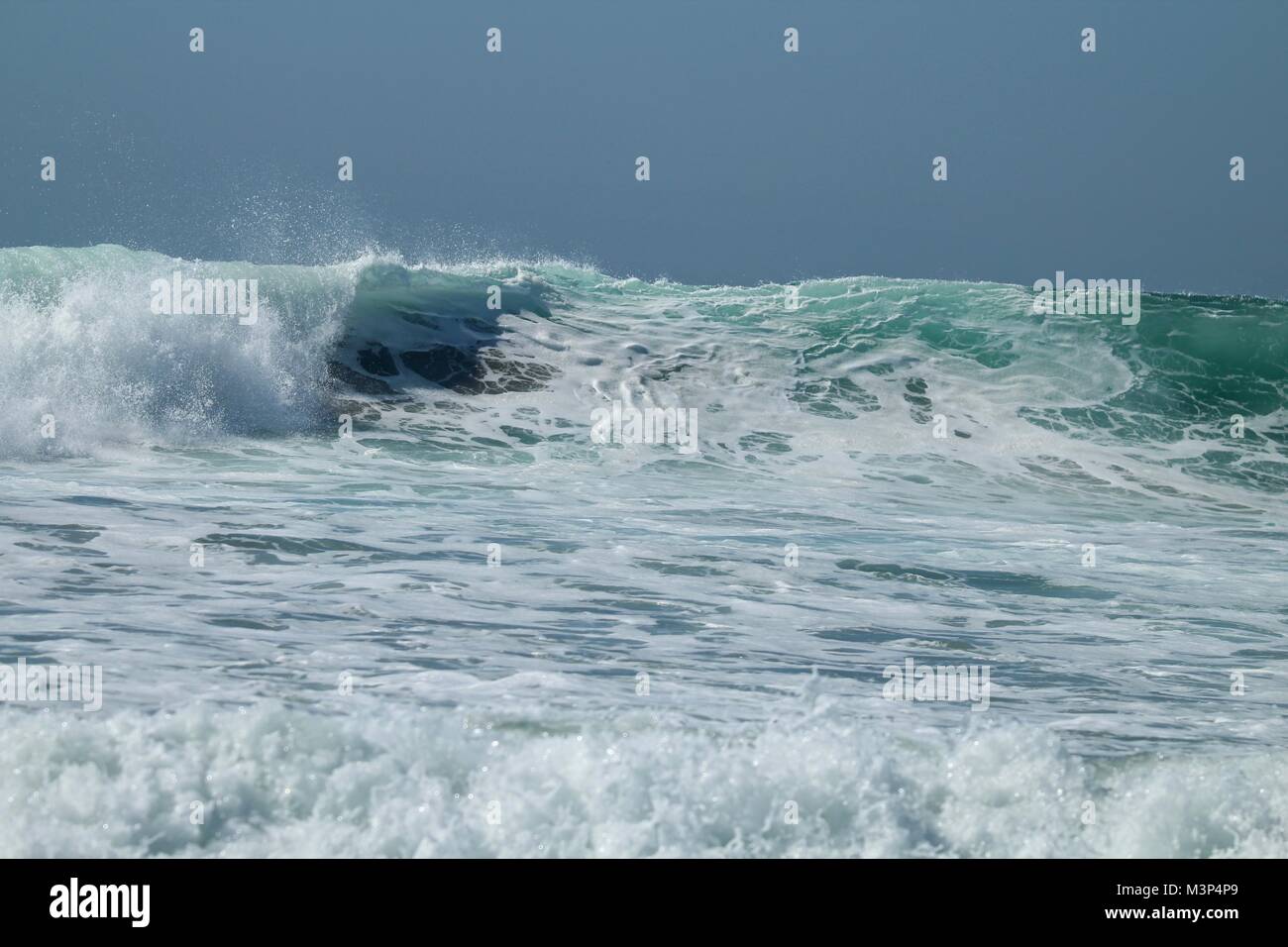 Onde si infrangono nell'oceano pacifico Foto Stock