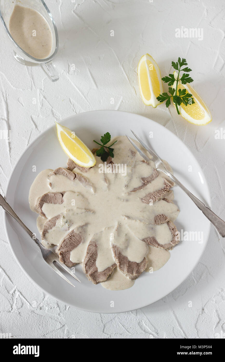 Vitello tonnato è un tradizionale piatto italiano su un cemento bianco sullo sfondo. Messa a fuoco selettiva. Foto Stock