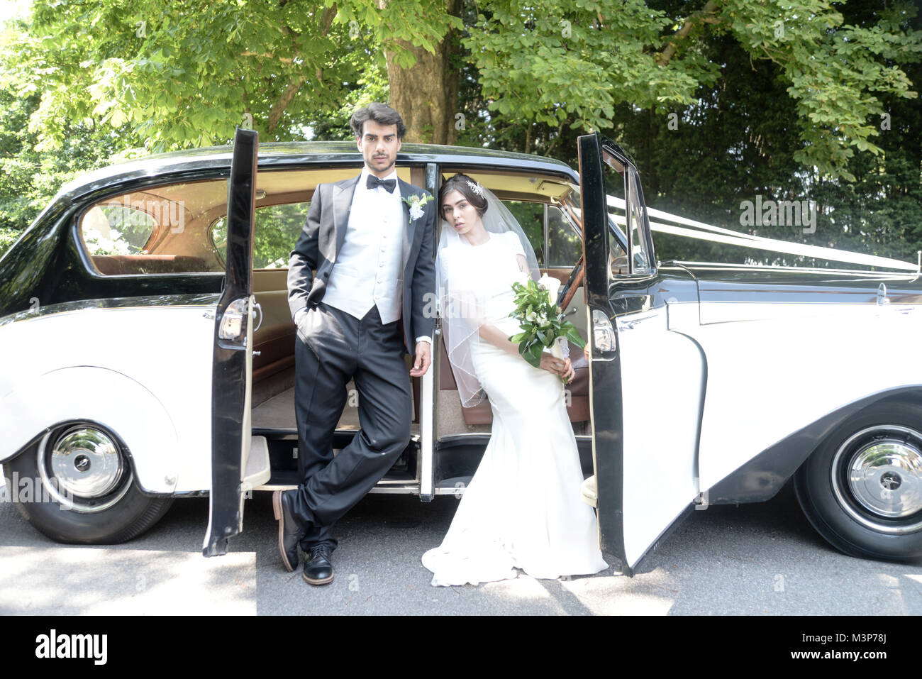 Bella dai capelli scuri gli sposi a un matrimonio in stile giorno-  tradizionale abito bianco/vestito nero-'atmosfera Art Deco- luminosa  giornata di sole Foto stock - Alamy
