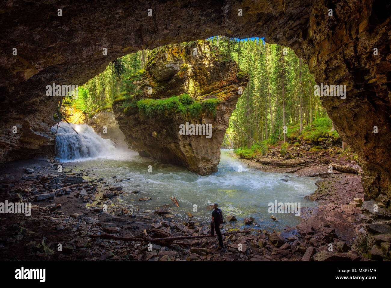 Escursionista guardando Johnston Creek da una grotta Foto Stock