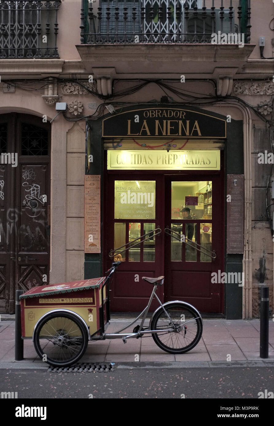 LA NENA vecchio negozio di catering facciata con consegna al di fuori di bicicletta in zona Gracia di Barcellona, Spagna. Foto Stock