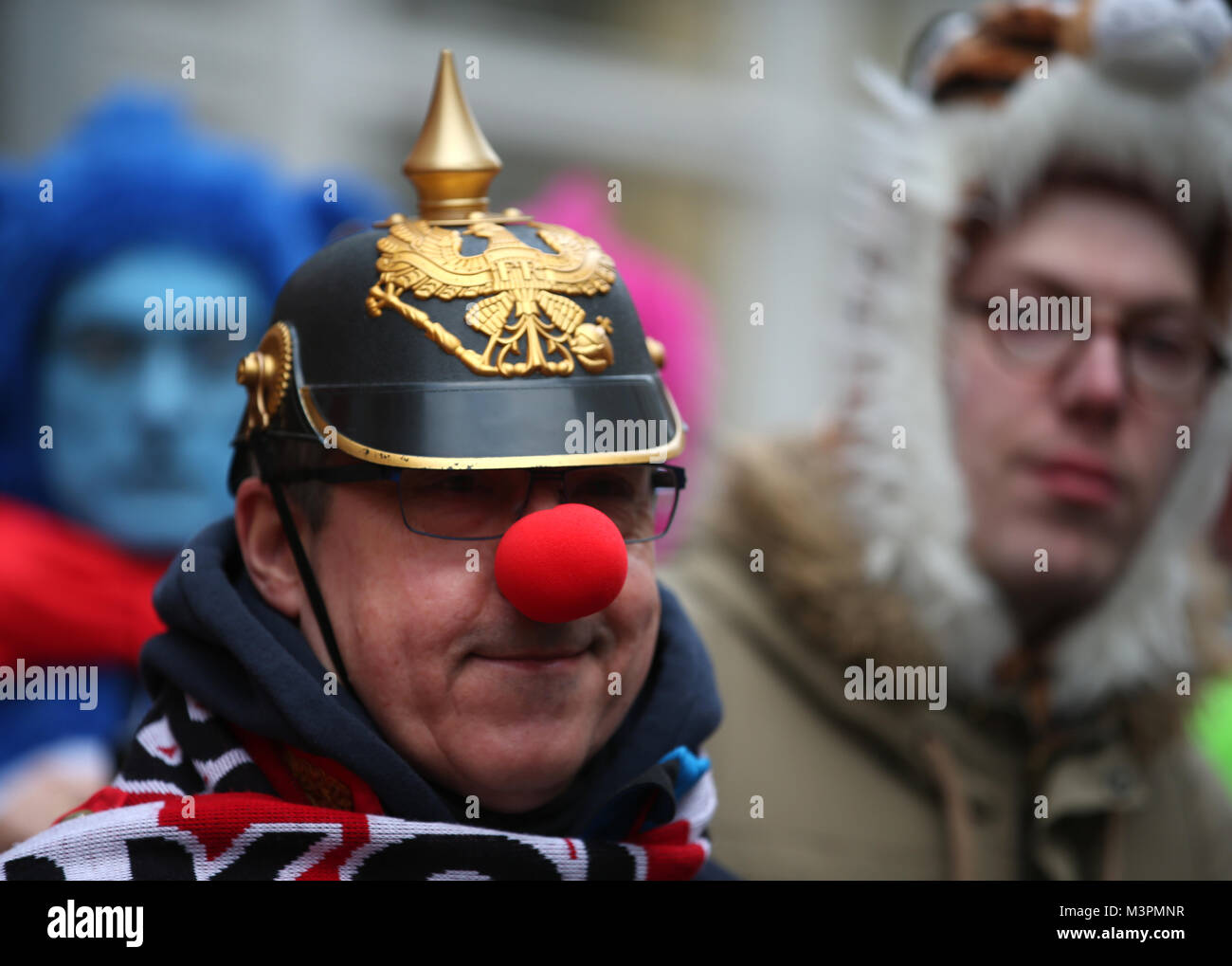 Duesseldorf, Germania, 12 febbraio 2018. Un carnevale-goer con un spiked casco e naso rosso prende parte al Rosenmontag (Martedì grasso lunedì) sfilata di carnevale a Colonia, Germania, 12 febbraio 2018. Foto: Oliver Berg/dpa Credito: dpa picture alliance/Alamy Live News Foto Stock