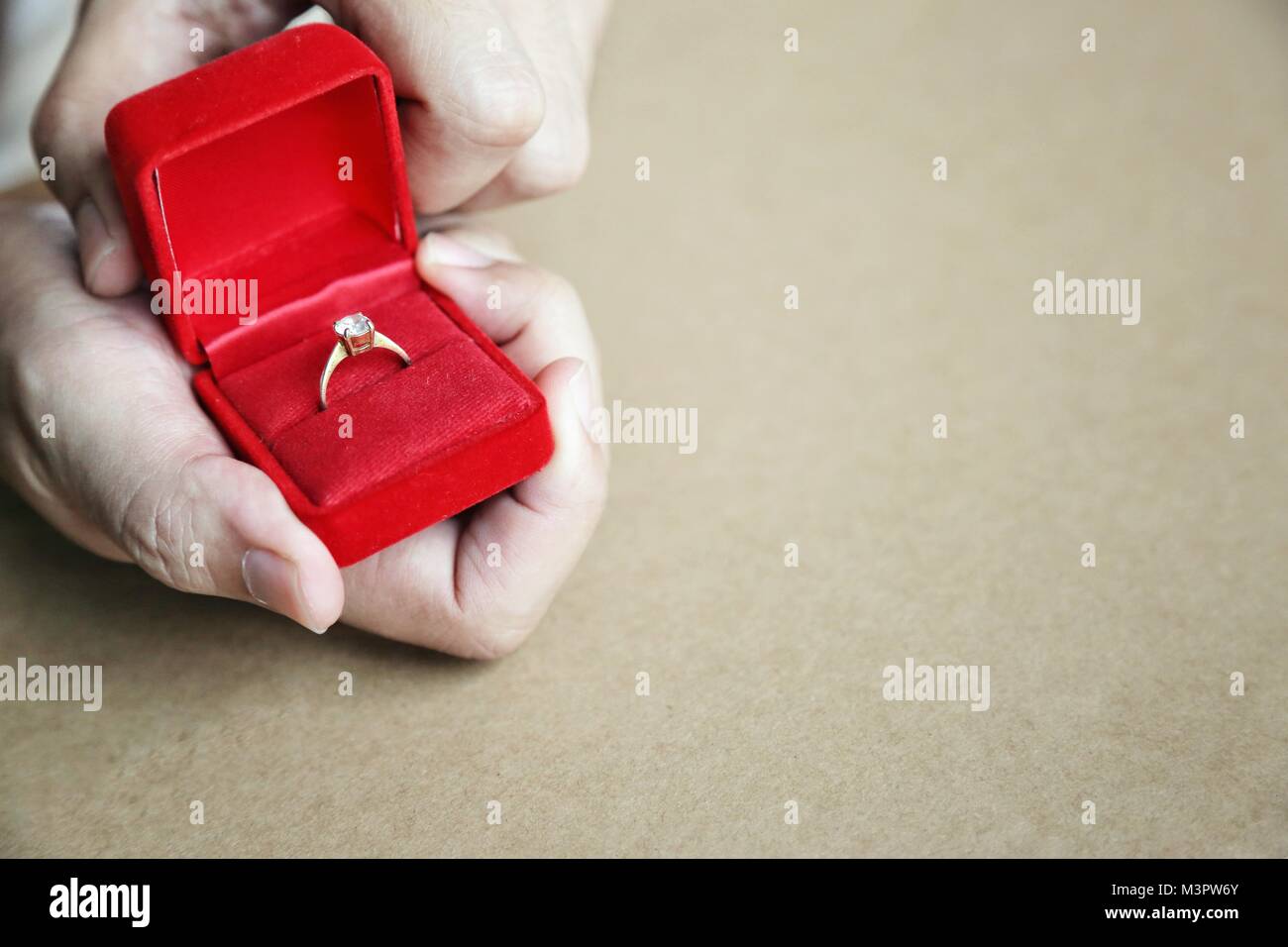 Confezione regalo rossa aperto con anello di diamante in Le Mans le mani. Concetto di anello di fidanzamento, Valentino regalo a sorpresa, simbolo di vivere. Foto Stock