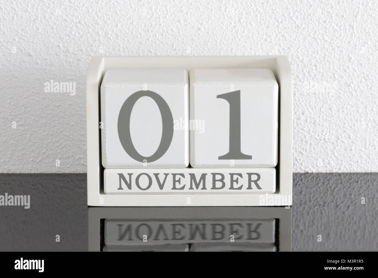Block Bianco calendario data presente 1 e il mese di novembre sul muro bianco sullo sfondo Foto Stock