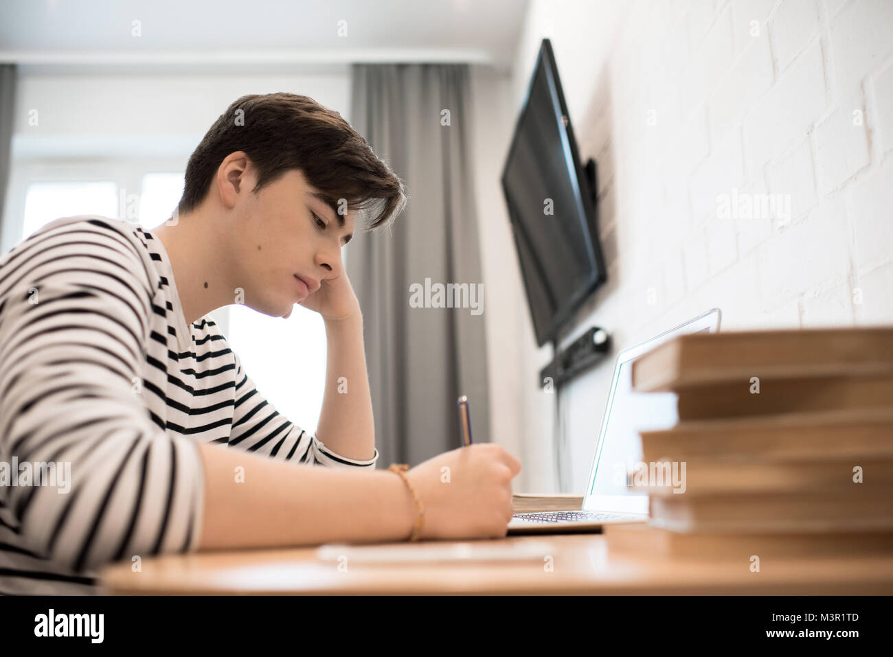 Giovane uomo facendo i compiti di scuola Foto Stock