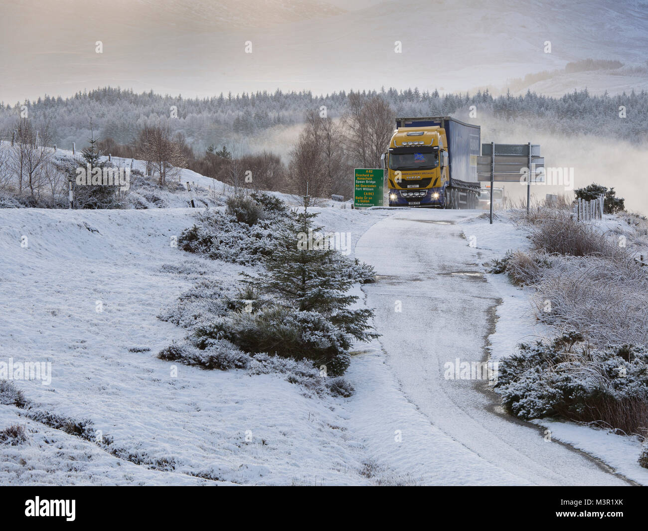 Autoarticolato viaggia sulla A82 in inverno. Come si vede dal commando Memorial vicino a Spean Bridge, Scotland, Regno Unito Foto Stock