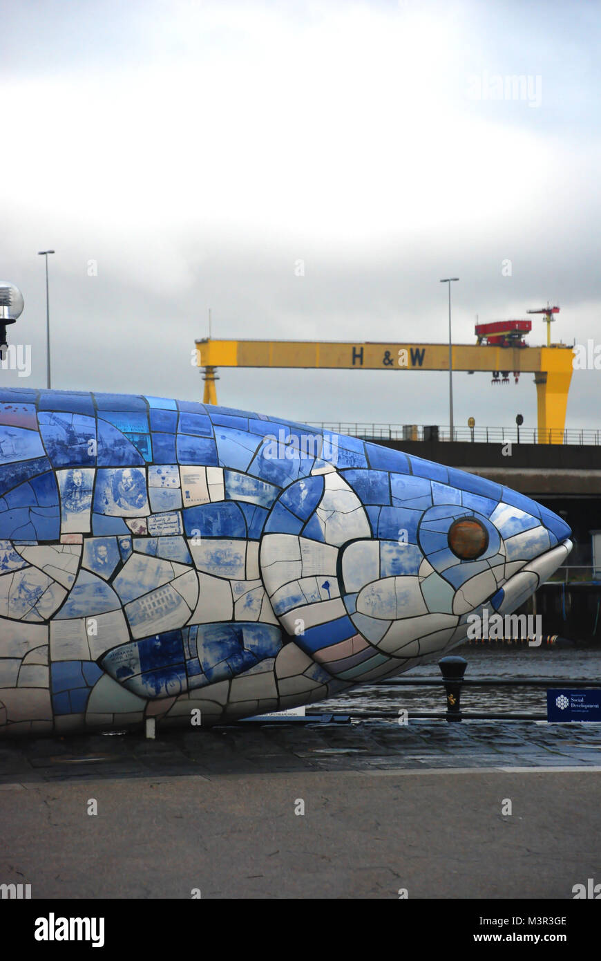 La grande statua di pesce e h&w gru in background, Belfast, Irlanda del Nord, Regno Unito Foto Stock