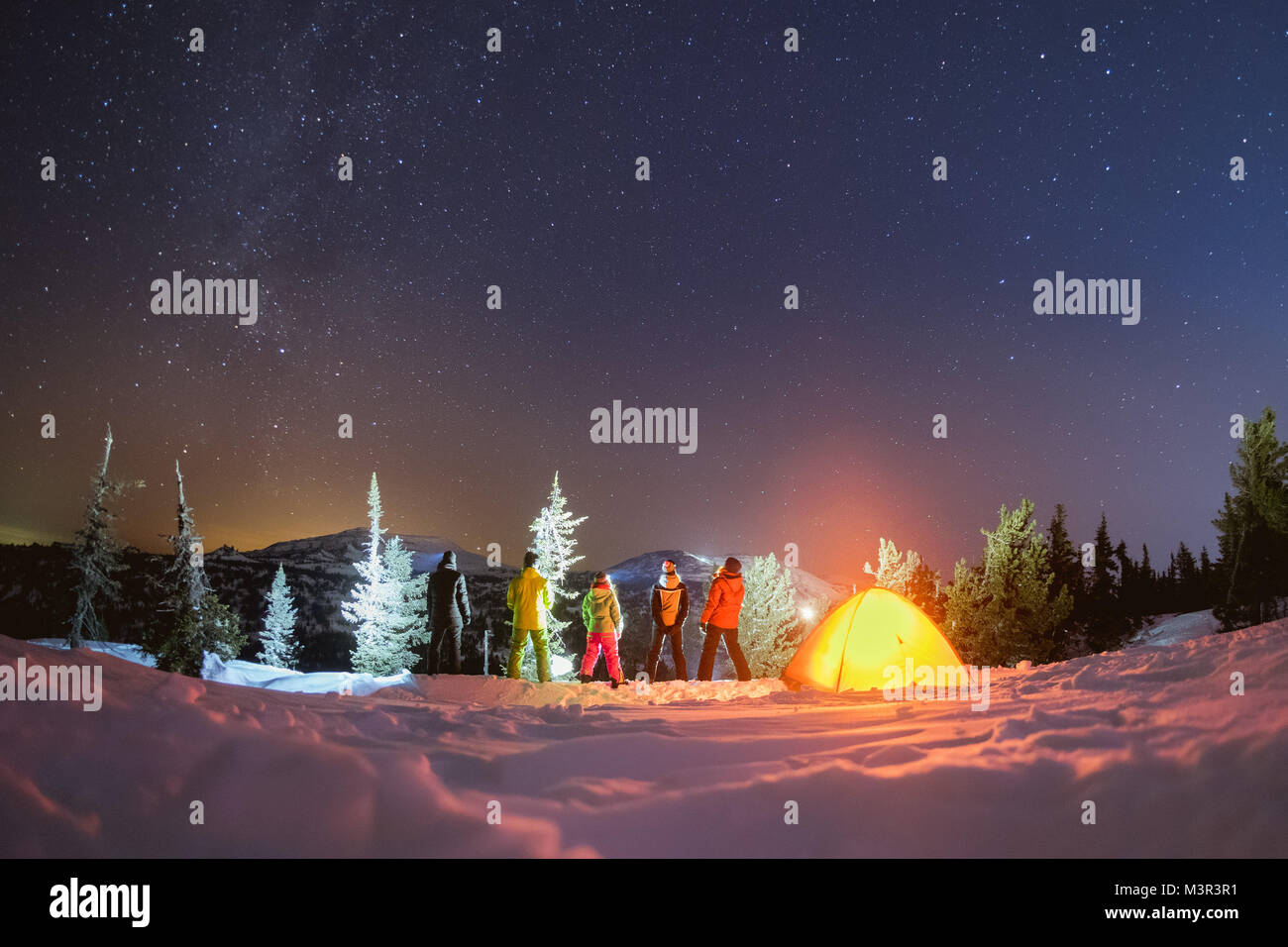 Viaggiare di notte inverno campeggio concetto con amici e tenda Foto Stock