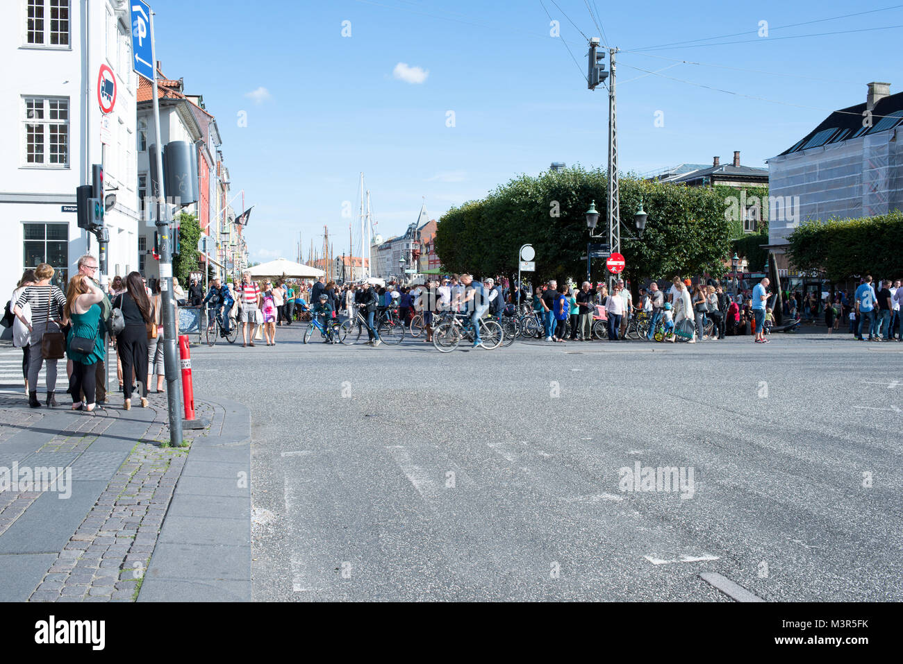 Attraversando a Kongens Nytorv e Nyhavn a Copenaghen in un giorno di estate con tanti ciclisti e turisti Foto Stock