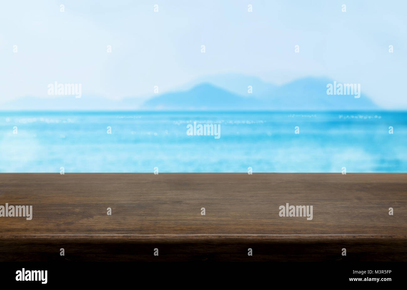 Svuotare il vecchio legno scuro tavolo con blur blu del cielo e del mare sullo sfondo bokeh di fondo,Mock up modello per visualizzare o montaggio del prodotto contenuto o utilizzare come intestazione Foto Stock