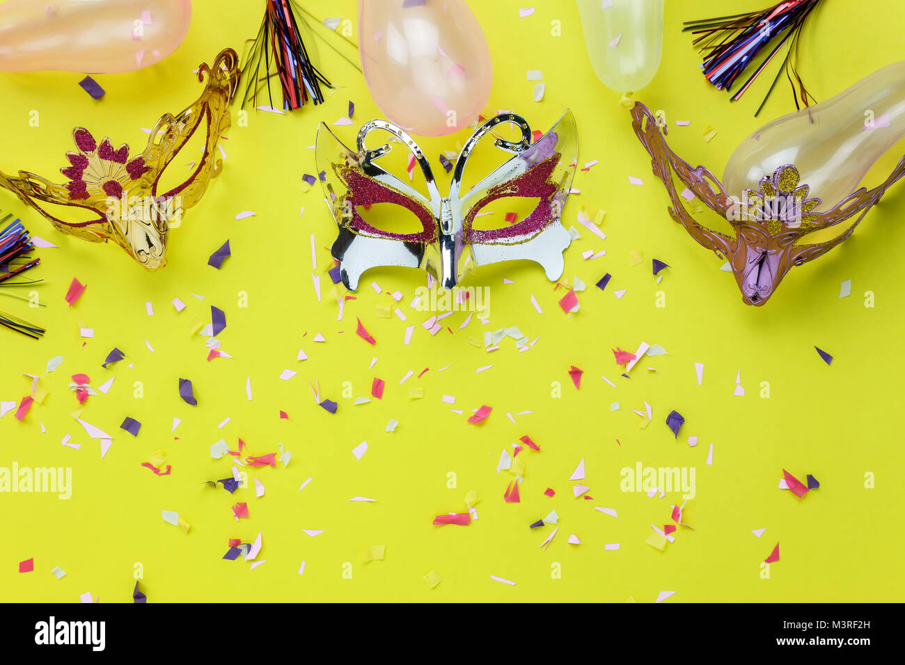Table top visualizza immagine aerea di bella colorata maschera di Carnevale sfondo.piatto accessorio laici oggetto sulla moderna carta gialla a home office desk studio Foto Stock