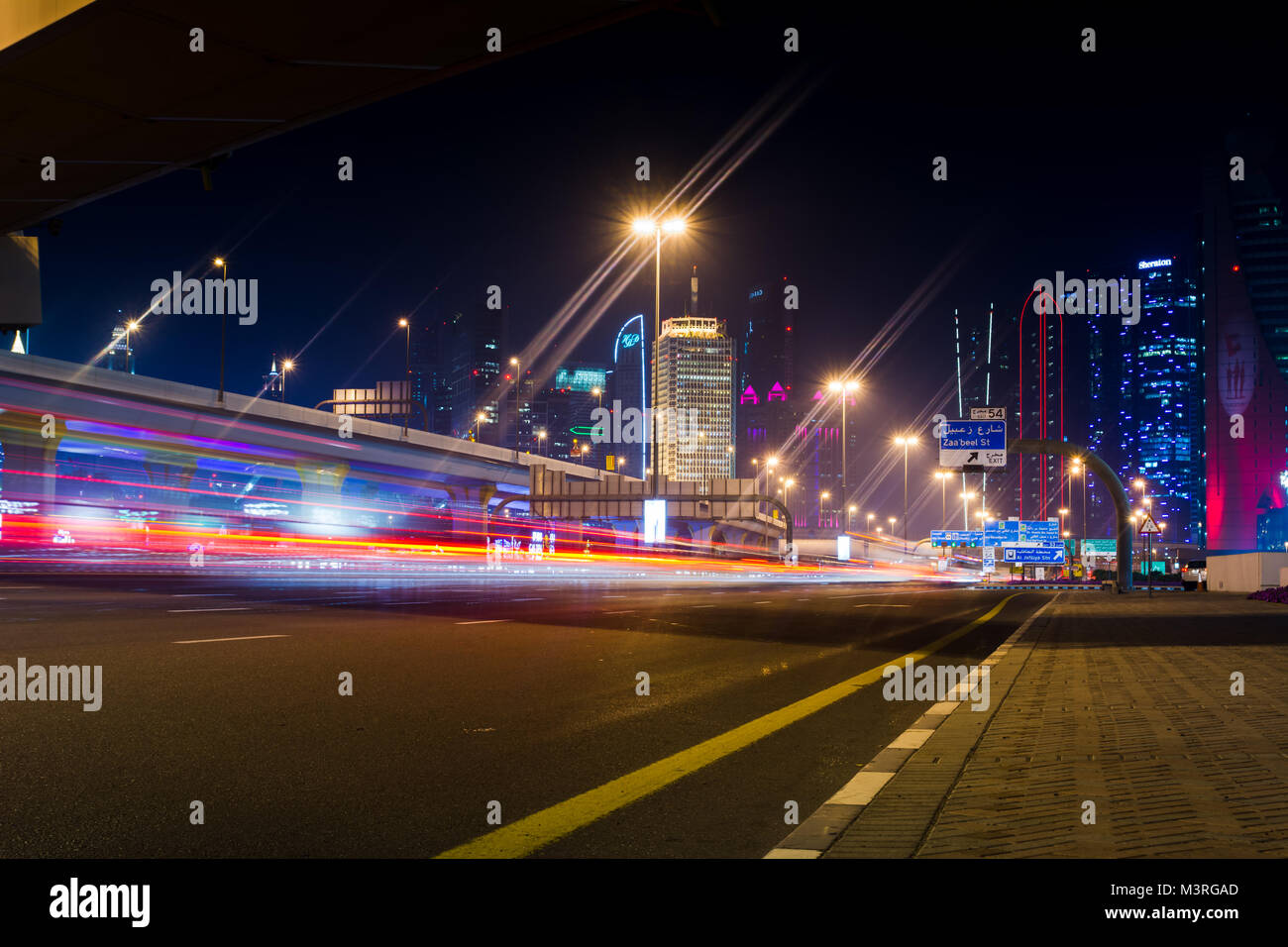 Dubai, Emirati Arabi Uniti, 11 Febbraio 2018: Dubai scena di strada con semaforo sentieri e nuova città vista di notte Foto Stock