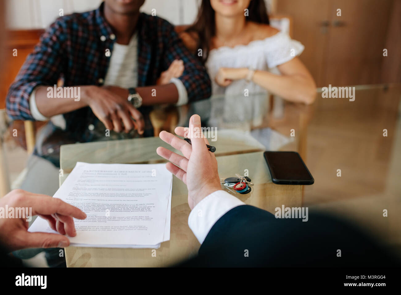 Agente immobiliare per spiegare i dettagli del contratto di leasing al giovane. Agente immobiliare in discussione con i nuovi proprietari in un appartamento. Foto Stock