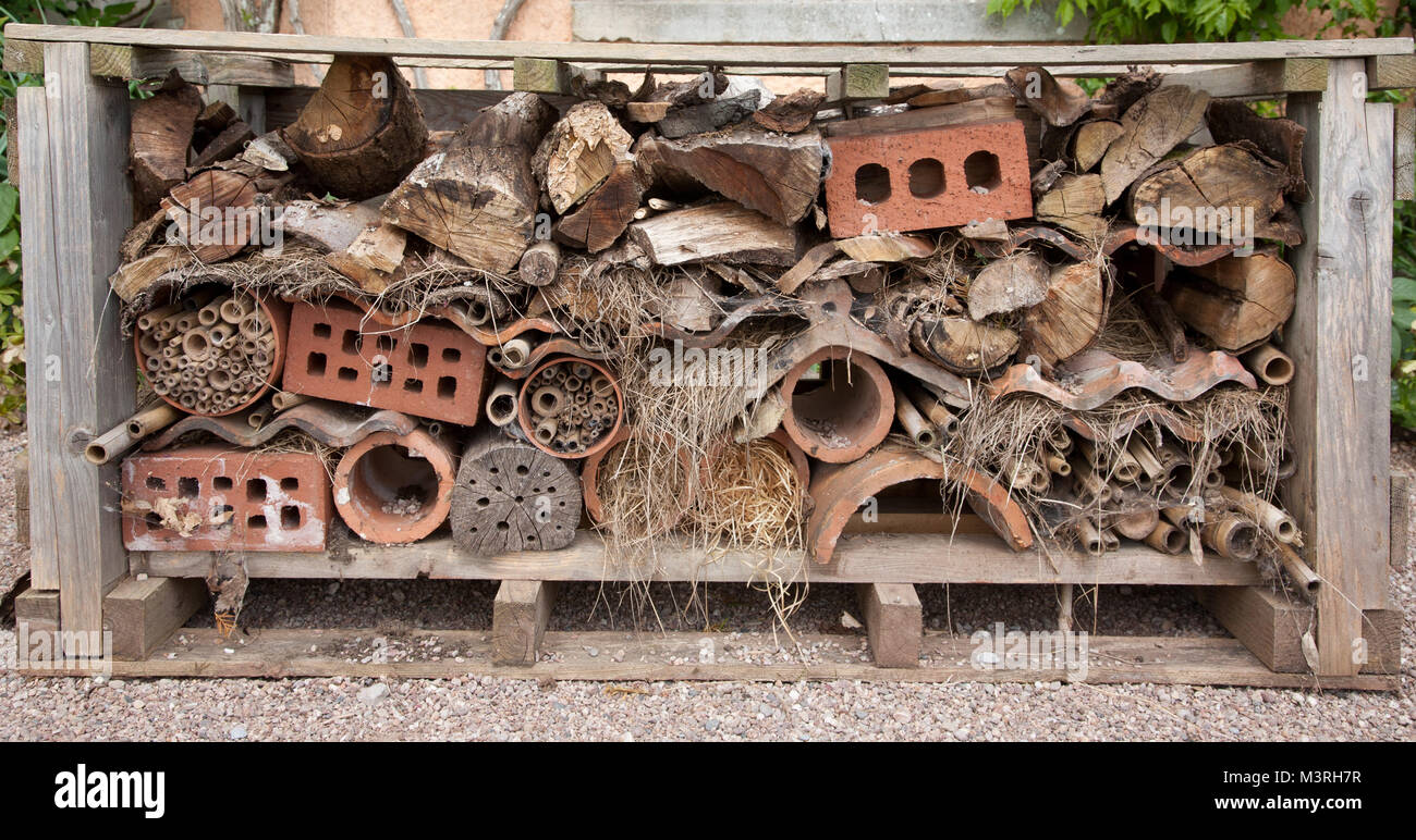 Hotel di insetto realizzato da log, aria di mattoni e di altri materiali riciclati, Killerton, Devon. Foto Stock