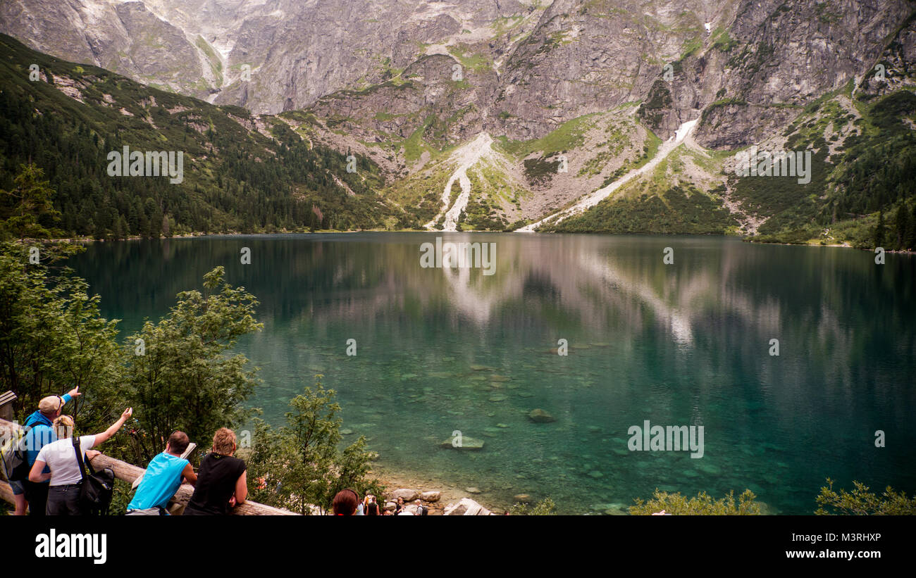 Il polacco Tatry Tatra, acque cristalline del lago / stagno nella valle di montagna sulla soleggiata giornata autunnale. Acqua riflessioni, mountain e il mirroring del cielo. Foto Stock