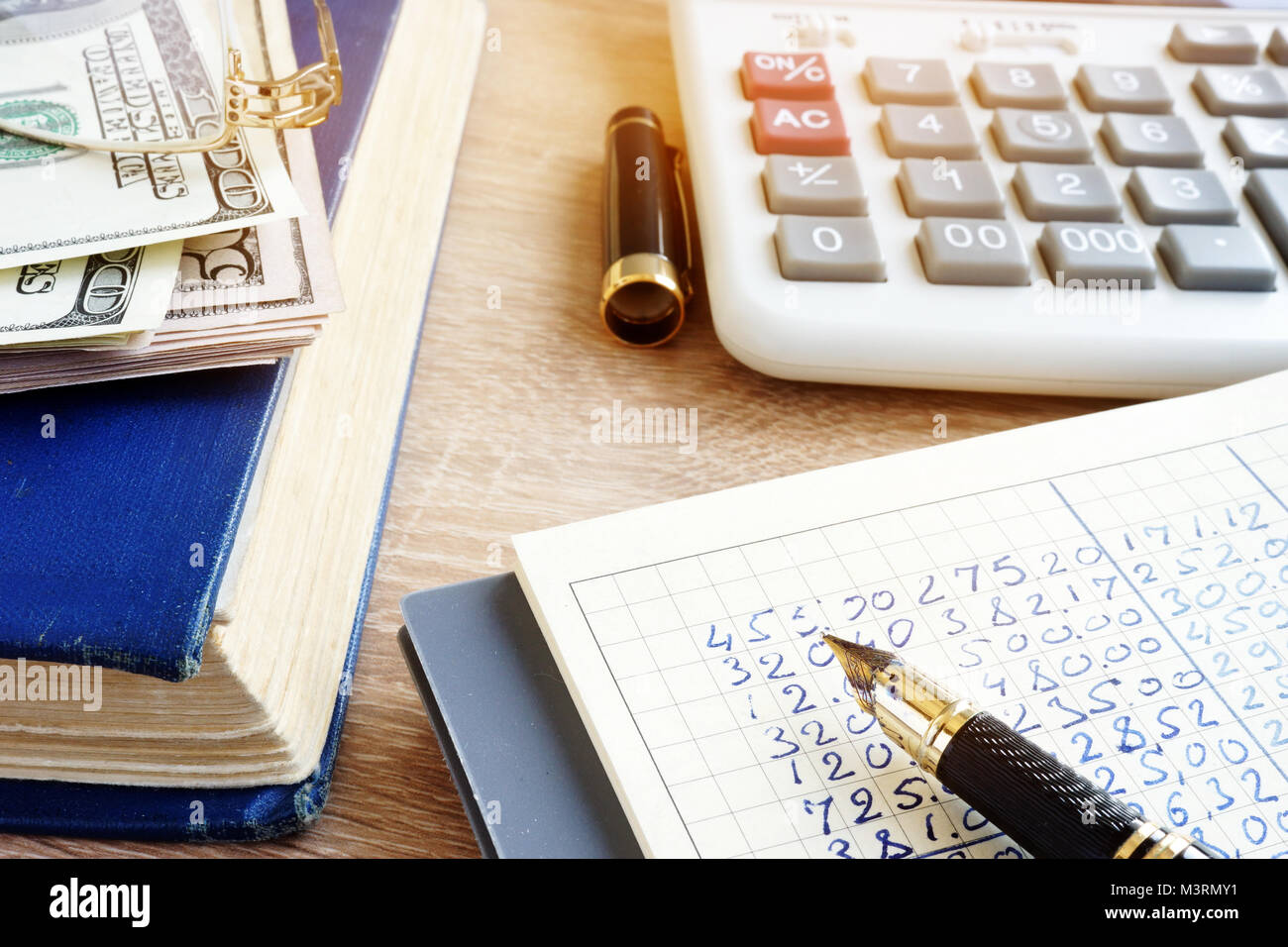 Libro contabile, la valuta e la calcolatrice. Home finanze. Foto Stock