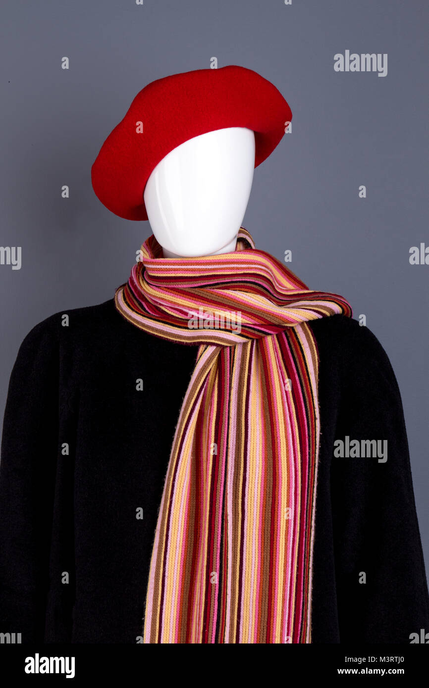 Berretto rosso, sciarpa e nero soprabito. Foto Stock