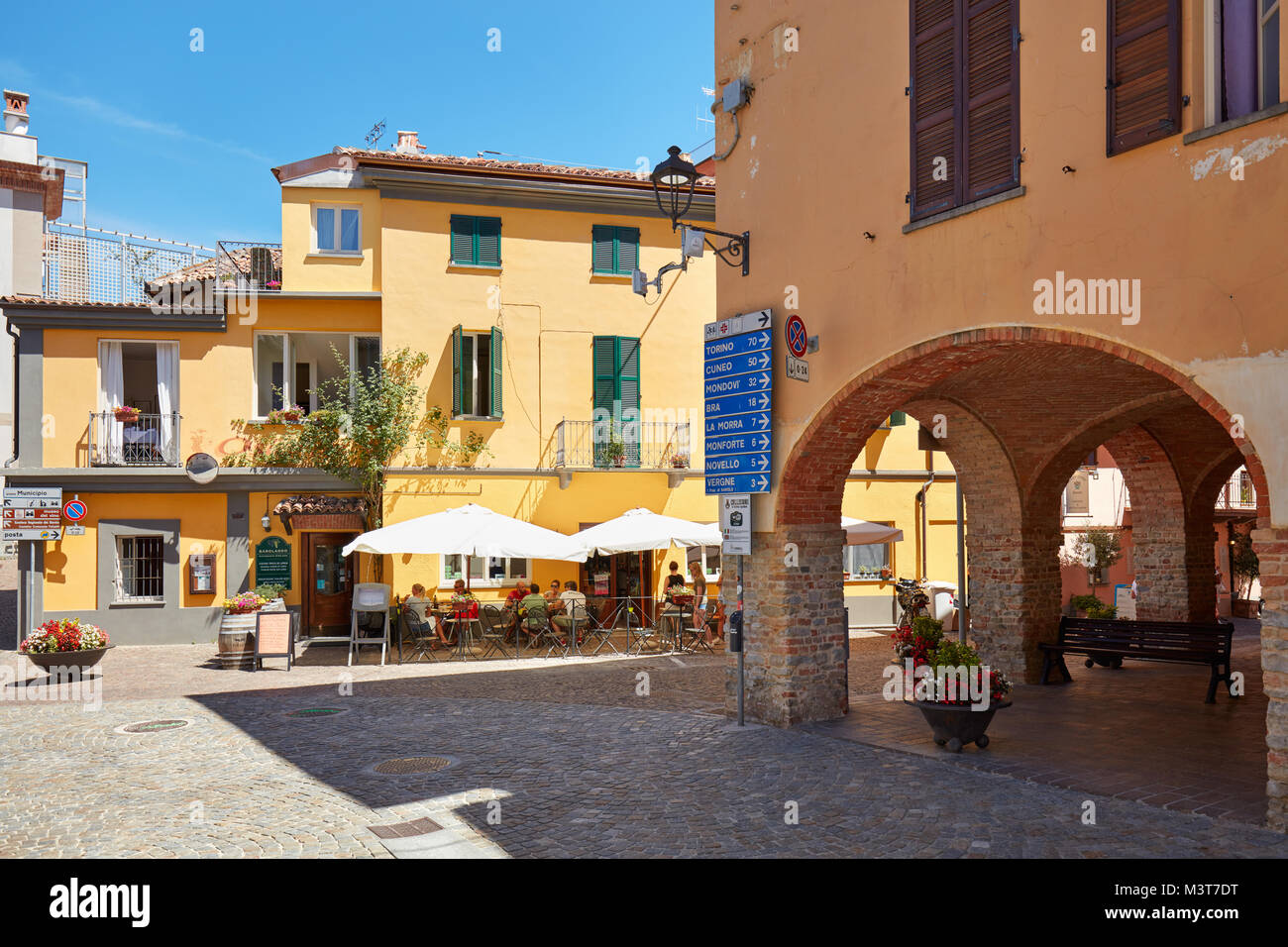 Il Barolo strade, archi e ristorante sul marciapiede in una soleggiata giornata estiva in Piemonte in Barolo, Italia. Foto Stock