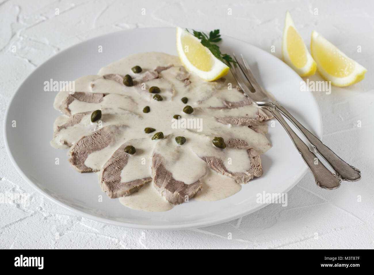 Vitello tonnato è un tradizionale piatto italiano su un cemento bianco sullo sfondo. Messa a fuoco selettiva. Foto Stock