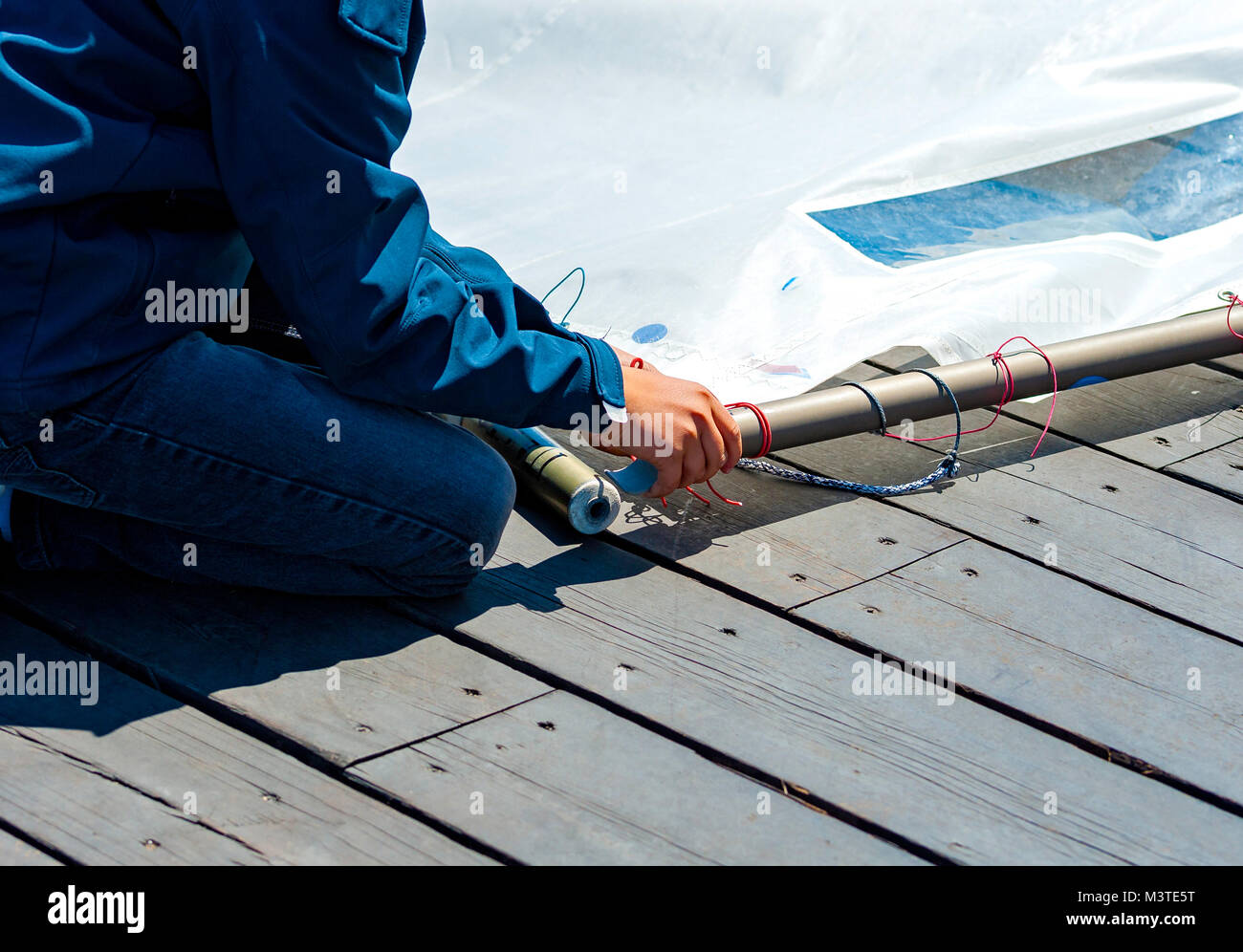 Gli aspiranti sailor prepara la vela della sua barca il corso di vela. Foto Stock