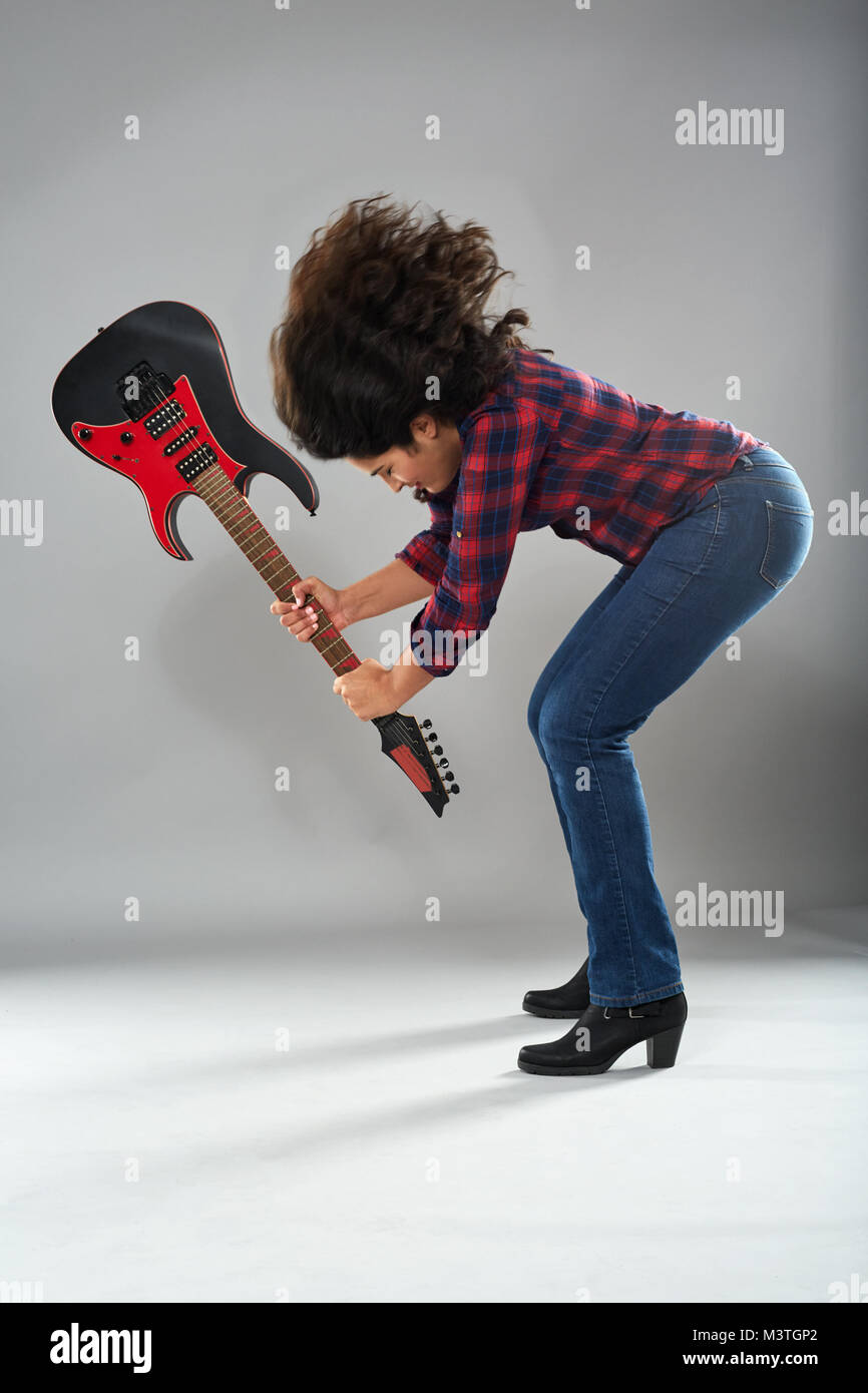 Donna chitarrista smashing la sua chitarra elettrica Foto stock - Alamy