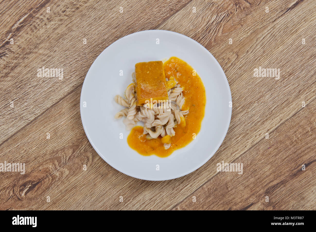 Il tofu e salsa di zucca con la pasta su una tavola di legno Foto Stock