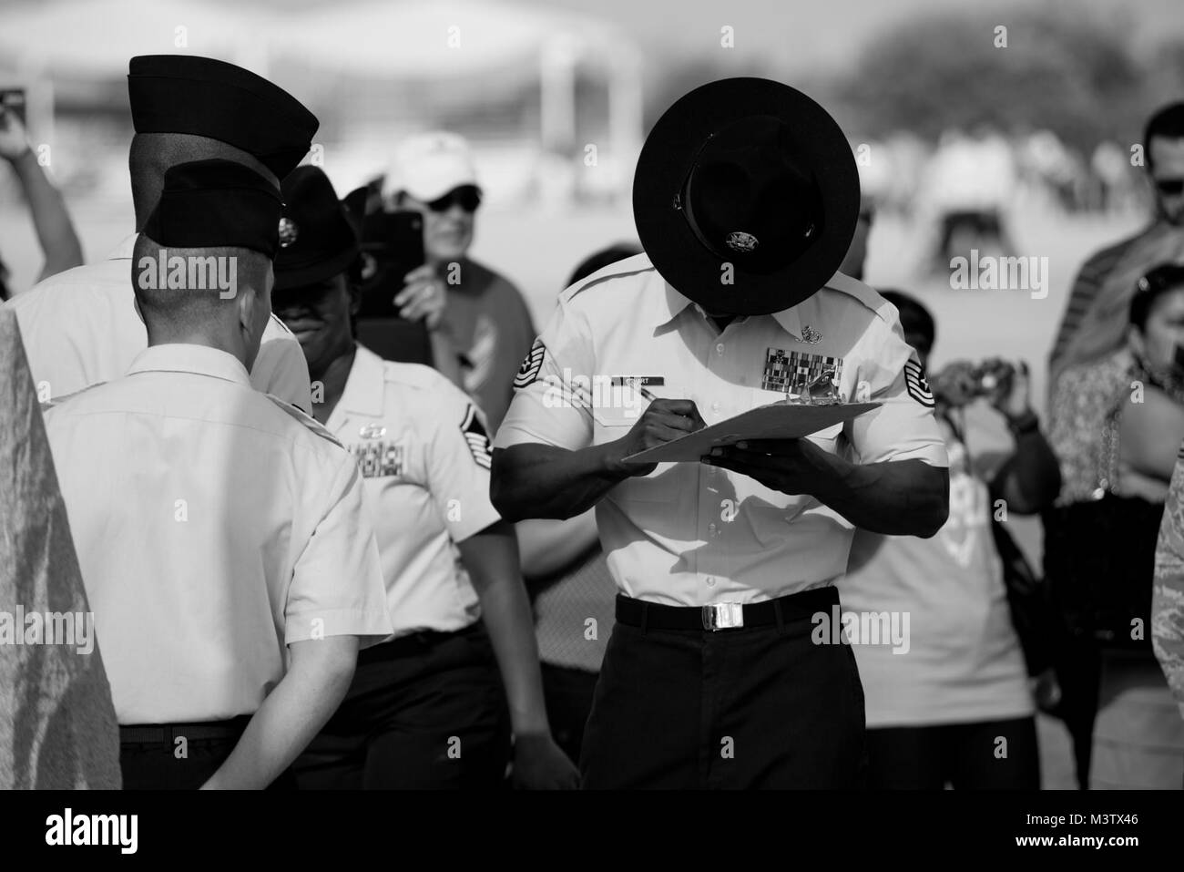 L'addestramento militare istruttore, Tech. Sgt. Chananyah Stuart, segni di documenti cartacei dopo aver completato la cerimonia di laurea a base comune San Antonio-Lackland. (U.S. Air Force foto di Master Sgt. Jeffrey Allen) 140926-F-CP197-0401 da AirmanMagazine Foto Stock