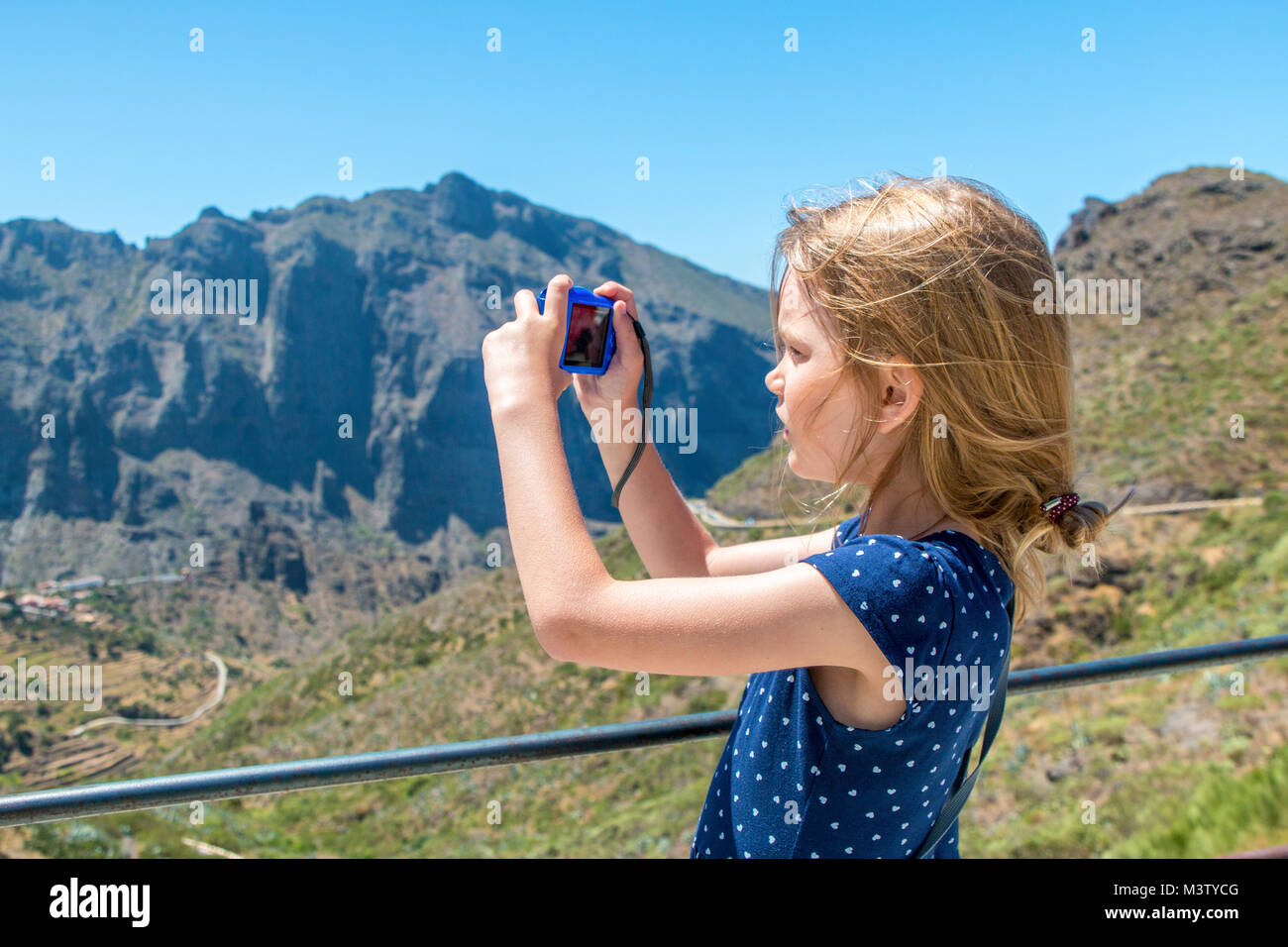 Ragazza con i capelli disheveled fotografie di un paesaggio di montagna nella luce del sole Foto Stock