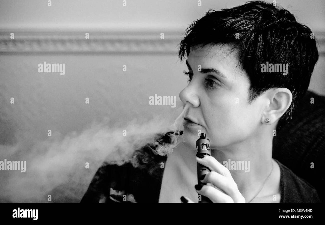 Femmina con e-sigaretta, vaping e ri-riempimento Foto Stock