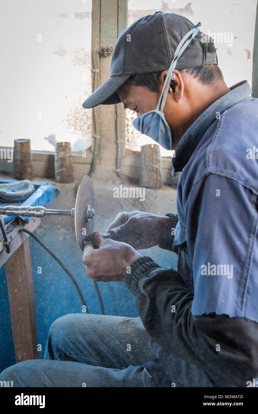 L'uomo facendo palette da zebù avvisatore acustico per turisti, Antsirabe, Madagascar Foto Stock