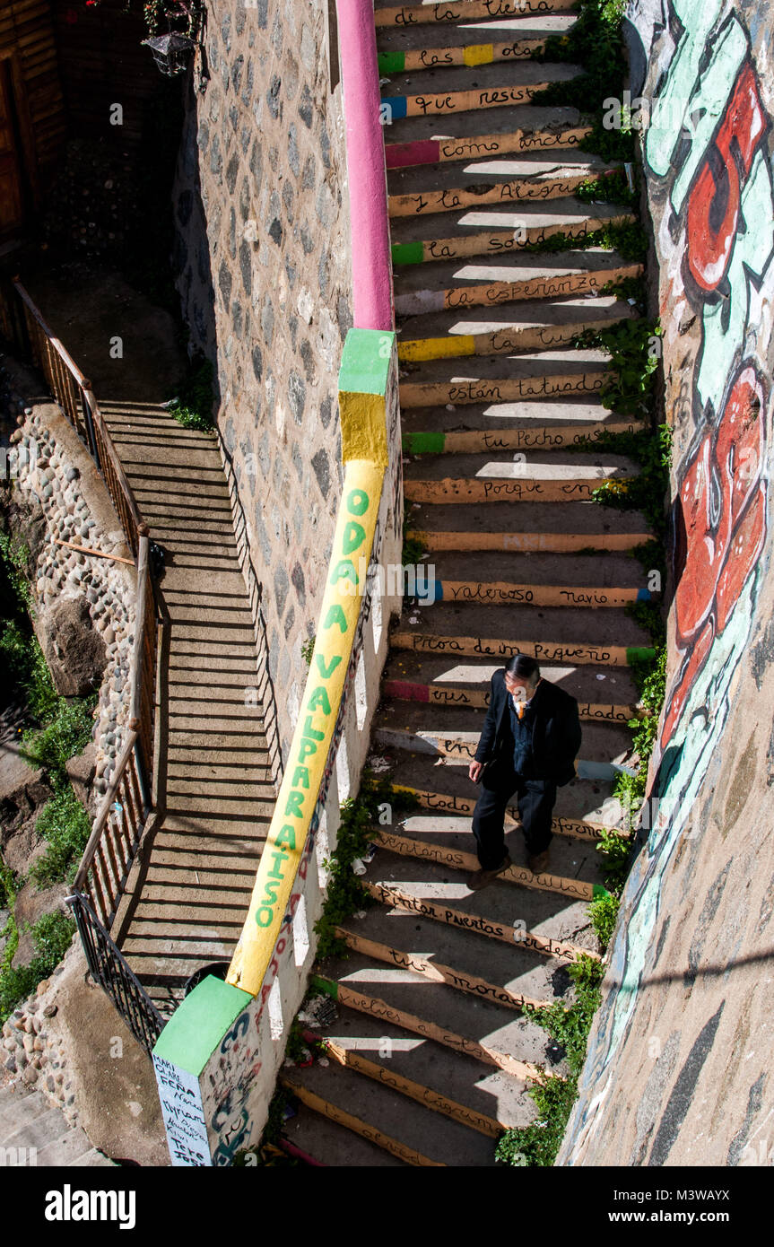 Un uomo a piedi giù per le scale con la poesia scritta su ogni passo in Valparaiso, Cile Foto Stock