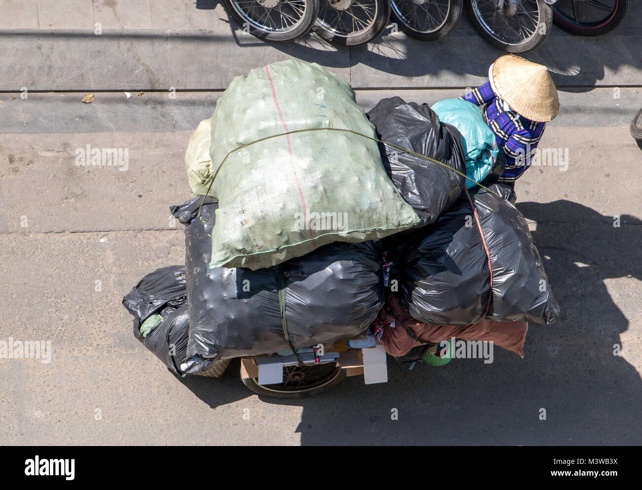A Saigon, Vietnam, DIC 17 2017, la raccolta di rifiuti riciclabili per le strade della città di Ho Chi Minh. Popolo vietnamita spingendo un carrello pieno di borse, Saigon Foto Stock