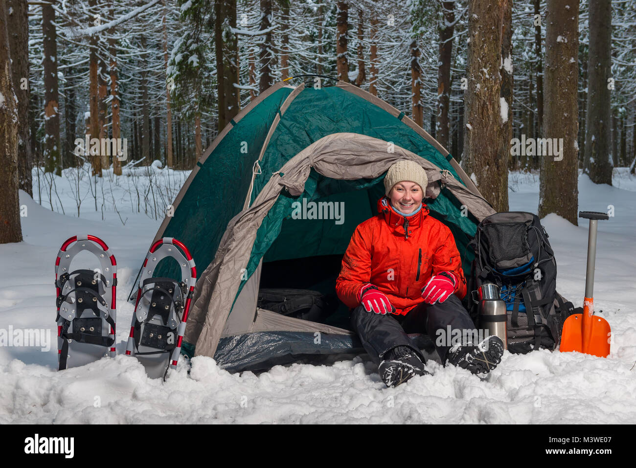 Felice turista attivo si trova nella foresta di inverno in tenda Foto Stock