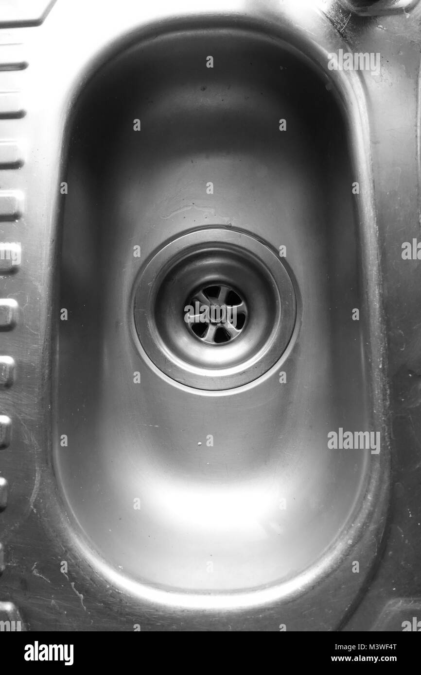Sporco e graffiato cucina domestica lavandino e il foro del tappo in bianco e nero. Foto Stock