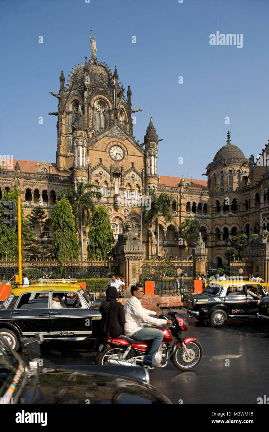 India, Mumbai, Chatrapati Shivaji Terminus (ex Victoria terminus), costruita in stile gotico. Il traffico nella strada trafficata. UNESCO - Sito Patrimonio dell'umanità. Foto Stock