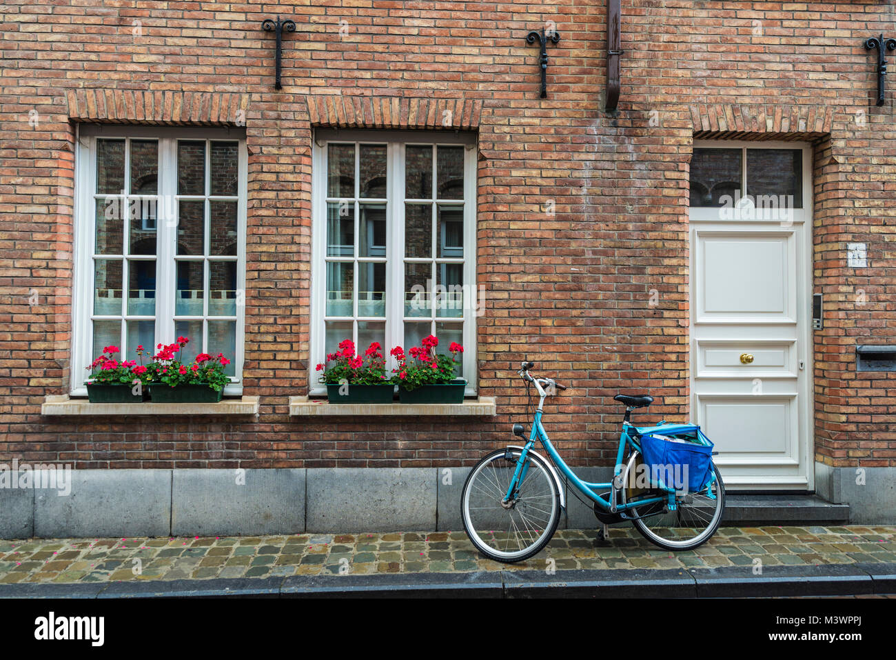Vecchio blu vintage bicicletta con una bisaccia parcheggiato su una strada della città medievale di Bruges, Belgio Foto Stock