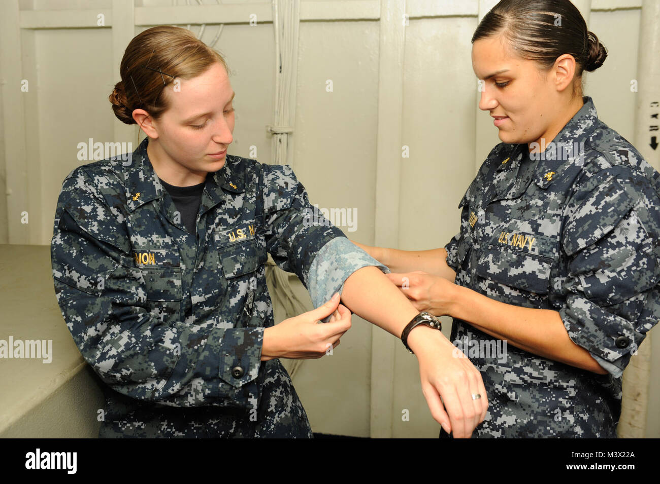 130623-N-IB033-166 Golfo di Oman (23 giugno 2013) - Guardiamarina di prima classe Christina Leyton, da Virginia Military Institute, rotoli i manicotti di Guardiamarina 2a classe Samantha Damon, presso la Oregon State University, nel secondo passaggio ponte modo a bordo della portaerei USS Nimitz CVN (68). Nimitz Strike gruppo è distribuito negli Stati Uniti Quinta Flotta area di responsabilità condurre le operazioni di sicurezza marittima, teatro la cooperazione in materia di sicurezza gli sforzi e le missioni di sostegno per l'Operazione Enduring Freedom. (U.S. Foto di Marina di Massa lo specialista di comunicazione di terza classe George J. Penney III/RILASCIATO) 23 giugno Bat Foto Stock