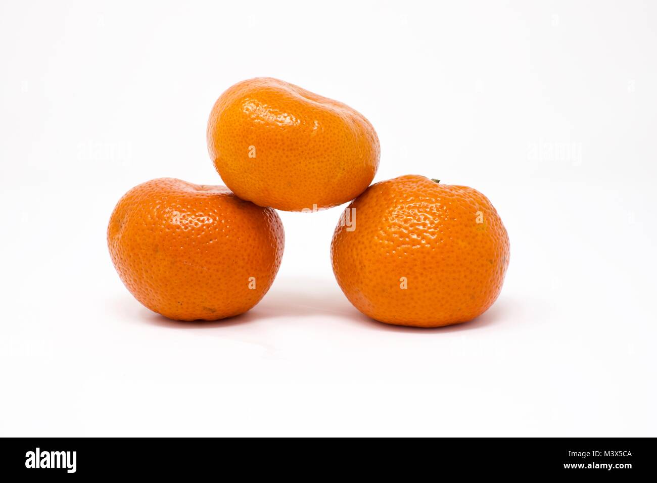 Tre le clementine ( Citrus clementina) su uno sfondo bianco Foto Stock