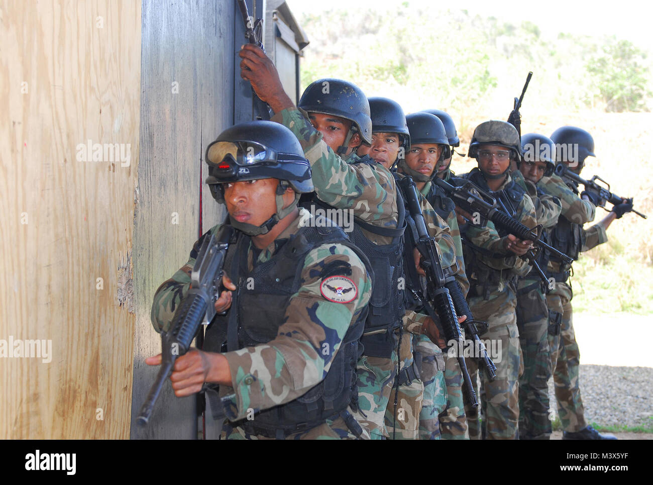 Commandos dominicana si muovono in una pila che si preparano a condurre la camera-operazioni di compensazione durante un close quarter battle esercizio vicino a Santo Domingo, Repubblica Dominicana, 3 marzo. La formazione era in preparazione per la risposta di Fuse 2011, di un insieme di Stati Uniti e Dominicana esercitazione militare, che si svolge il 7 marzo - 11, progettato per aumentare la capacità di lottare contro il terrorismo e il traffico illecito di droghe. (U.S. Esercito Foto di Sgt. 1. Classe Alex Licea, il Comando Operazioni Speciali Sud Affari pubblici) 20110303-A-WP252-004 da ussouthcom Foto Stock