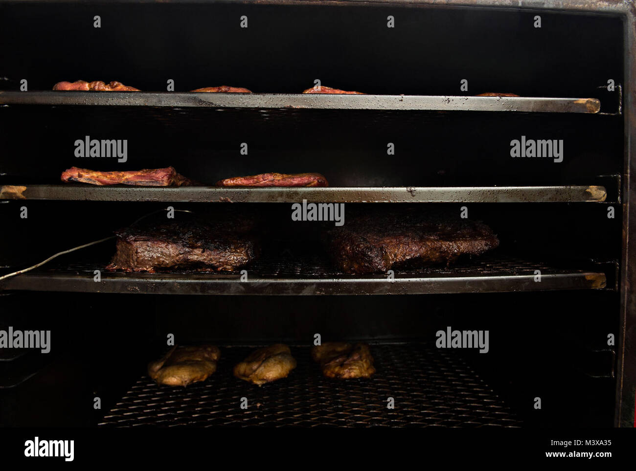 Pollo, manzo punta di petto e nervature riempire Tech. Sgt. Todd Houghton è ad alimentazione per gravità il fumatore. La carne in questo fumatore di Houghton ha vinto il primo posto nella sessione inaugurale del Air Force High Flyin' sfida BBQ. (U.S. Air Force foto/Staff Sgt. David Salanitri) 20140926-F-TM170-1044 da AirmanMagazine Foto Stock