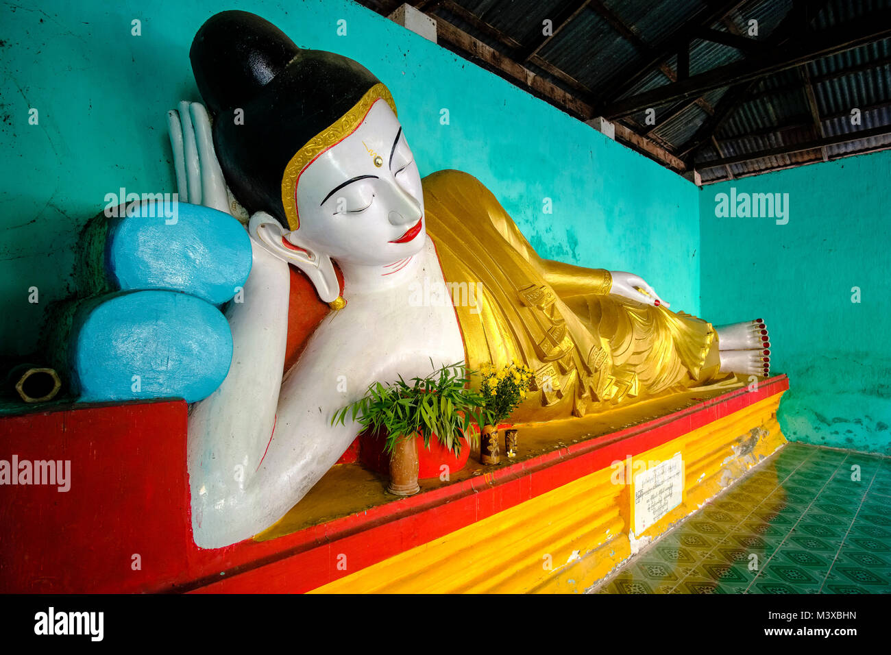 Un colorato Buddha sdraiato nei dintorni di Maha Gandar Yone monastero accanto a U Bein Bridge Foto Stock