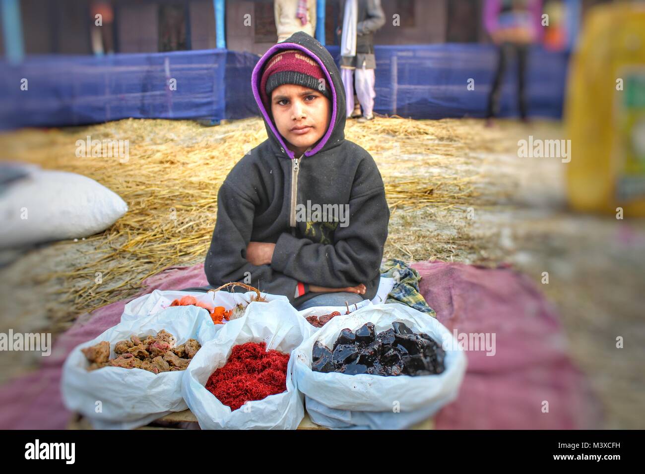 Indian ragazzo adolescente vendere colorato roba alimentare al Festival Foto Stock
