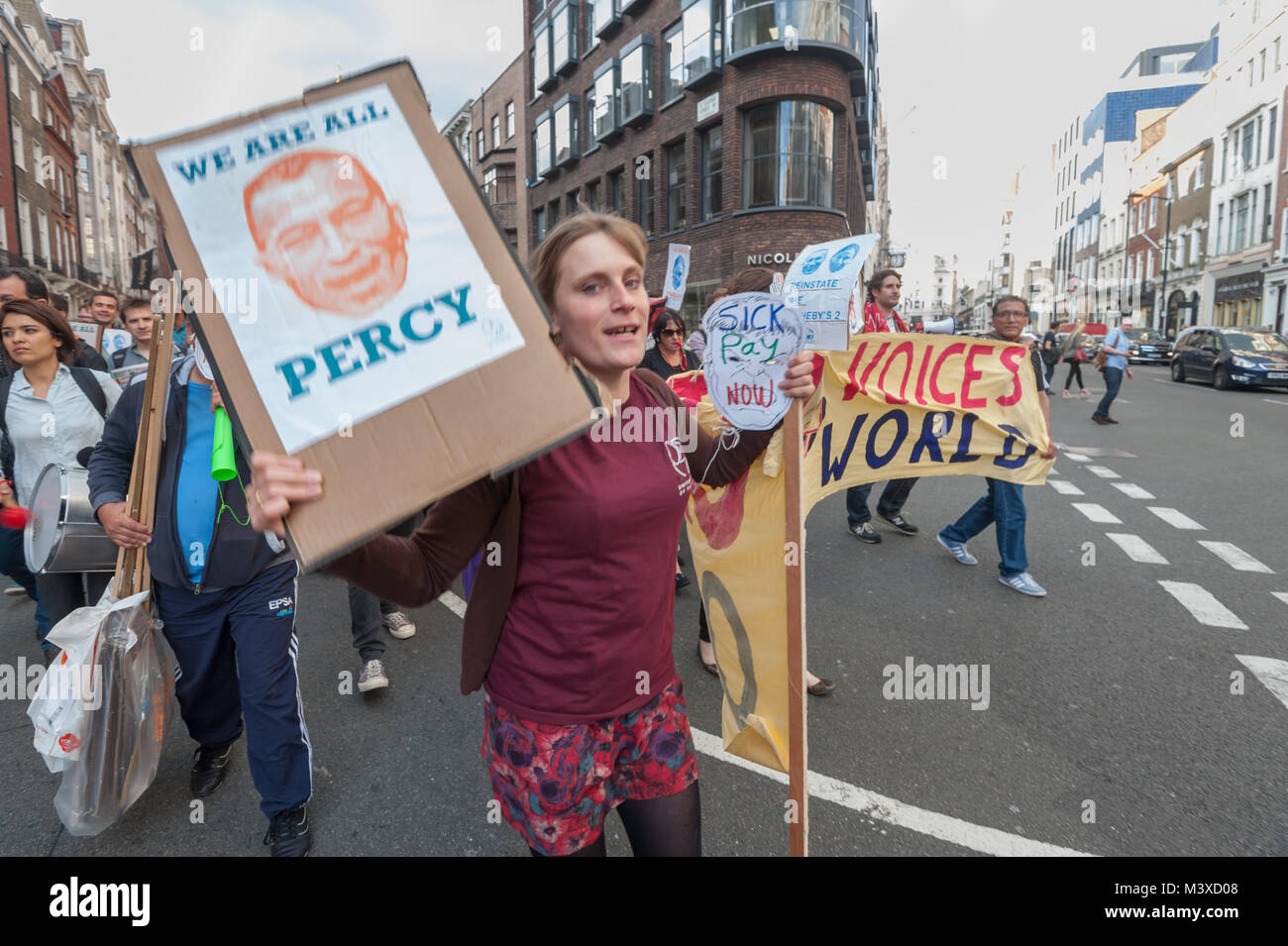 Vera Weghman del Regno voci del mondo trattiene il banner principale come si cammina intorno all'entrata frontale di Sotheby's per un rally impegnativo il reintegro di 2 lavoratori licenziati per protestare per malati pagare, vacanze le retribuzioni e le pensioni. Foto Stock