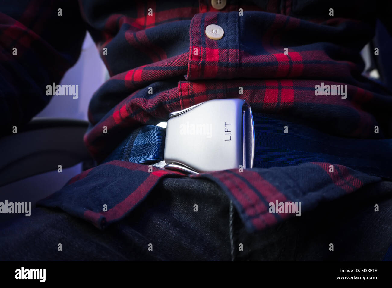 L'uomo che la cintura di sicurezza allacciata durante a bordo prima del decollo e atterraggio aereo per la sicurezza in ascensore. Foto Stock