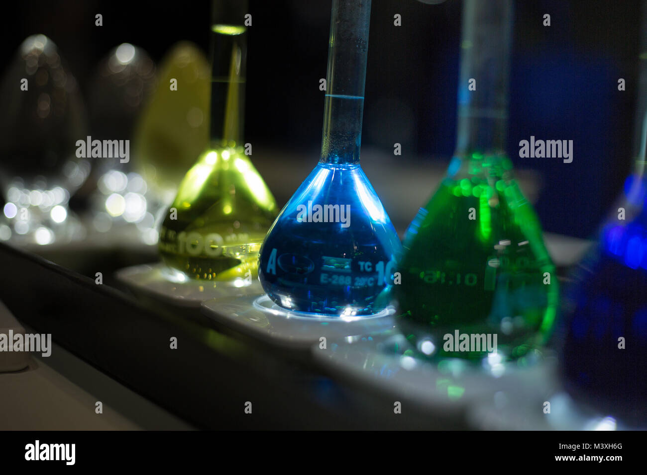 Concetto di test di laboratorio di chimica di vetro bottiglie sfondo scuro Foto Stock